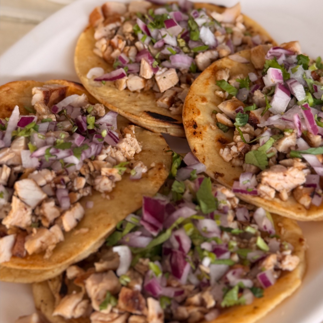 Orden de tacos de asada con cebolla morada y cilantro